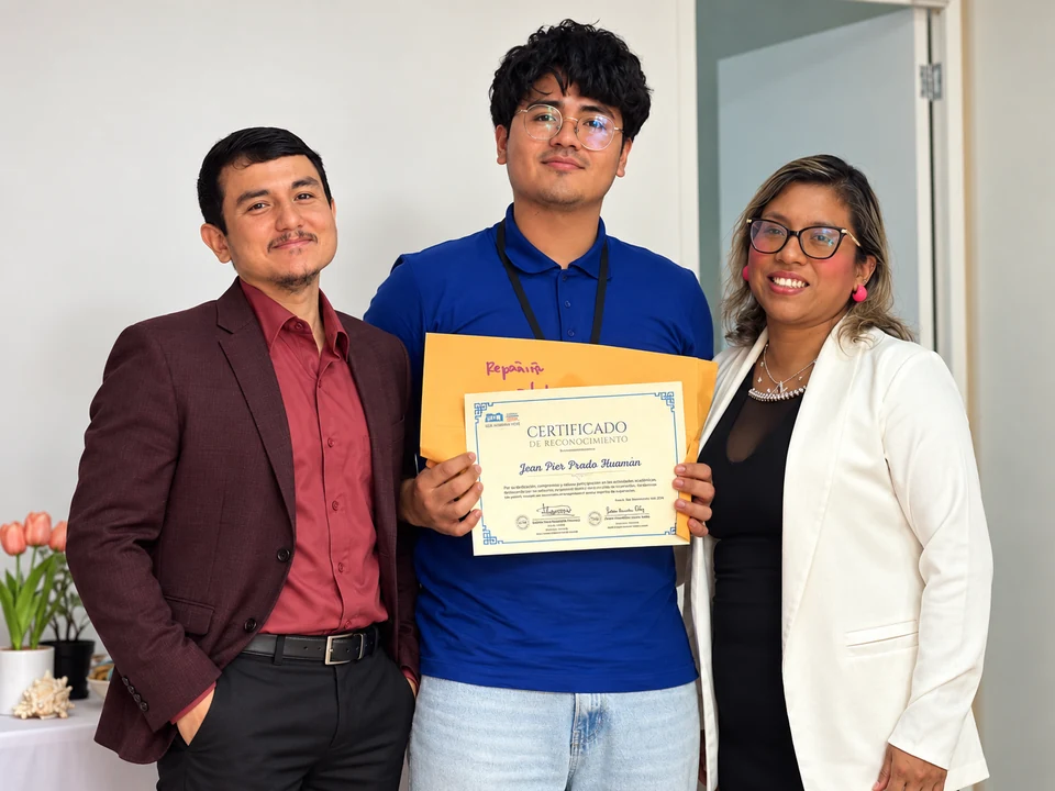 Integrante de KJA con camisa azul recibiendo su reconocimiento junto al equipo